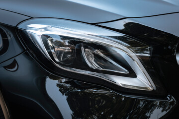 A close up image of a modern frontal car's headlight. Modern lines.