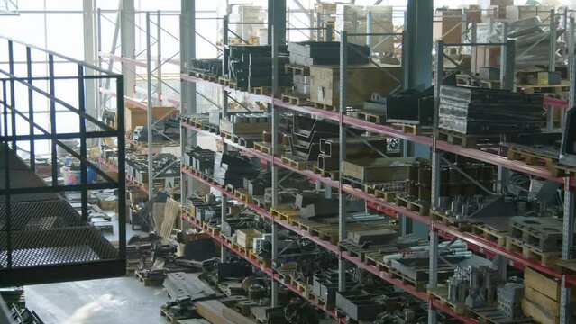 Wide no people high angle shot of warehouse with goods and spare parts on multiple storage shelves at manufacturing factory