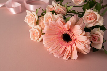Gerbera and roses fresh flower closeup over pink background. Feminine greeting card