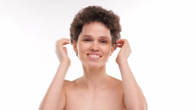 curly brunette girl enjoys her new short hairstyle plays with her hair