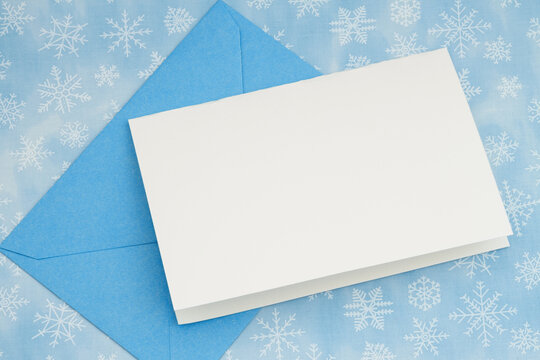 Blank greeting card with blue envelope on snowflakes