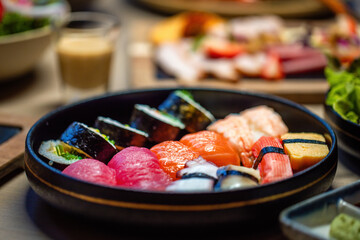 Assorted sushi set on round plate with soy sauce. Japanese cuisine and gourmet dining.