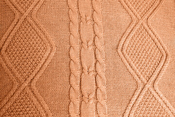 Knitted wool background. Peach Fuzz is the trendy color of the year 2024 .