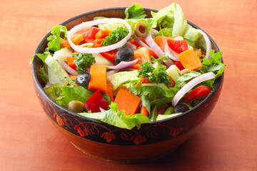 Vegetable salad with feta cheese. Vegetable salad in bowl. Fresh healthy salad with olives, carrot, tomato, onion, lettuce