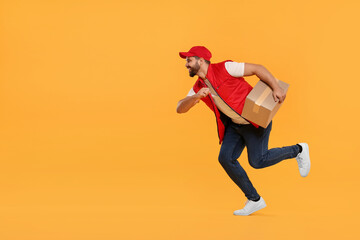 Fototapeta na wymiar Smiling courier running to deliver parcel on orange background, space for text