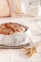 Multigrain loaf of round bread in a bright spring kitchen.