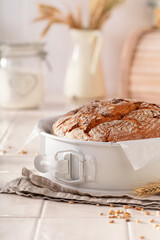 Multigrain loaf of round bread with grain and ears.