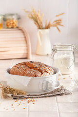 Fresh loaf of round bread in a bright spring kitchen.