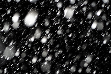 Bokeh effect of snowfall and lights. Abstract blurred background with snowflake in the night sky,...