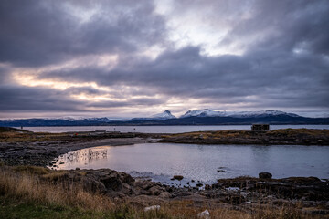 coastline of norwegian sea in bodo with snowy mountains on background