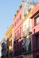 Fototapeta na wymiar Colorful buildings in the famous Triana neighborhood of Seville. Colorful facades in the Triana district. Colorful neighborhood of Seville.
