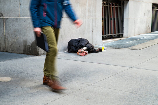 Unrecognizable homeless man lying on street