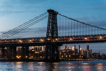 Fototapeta premium Illuminated bridge over river in evening city
