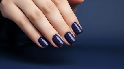 Fotobehang Glamour woman hand with navy blue nail polish on her fingernails. Navy nail manicure with gel polish at luxury beauty salon. Nail art and design. Female hand model. French manicure. © Artinun