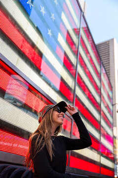Stylish woman in front of digital American flag in Times Square