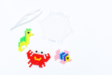 crab made of beads, children's crafts on a blue background.