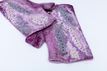 Close-up of purple knitted mittens on white background