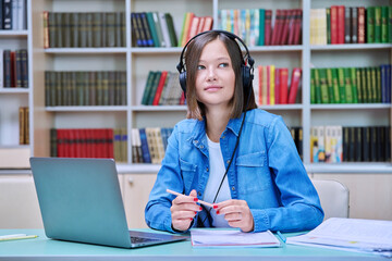 Young female university student studying inside library