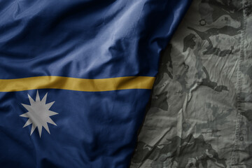 waving flag of Nauru on the old khaki texture background. military concept.