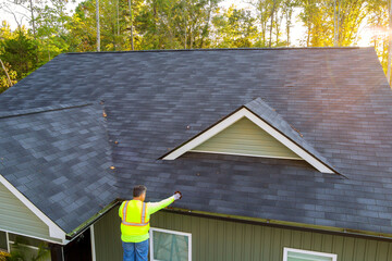 As worker is cleaning clogged roof gutter drain from dirt, debris, fallen leaves, he discovers it...