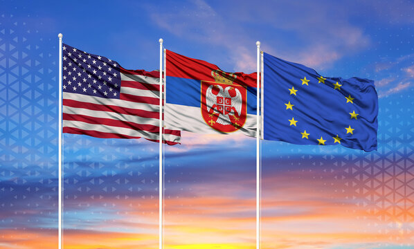 Three realistic flags of European Union, United States and Serbia on flagpoles and blue sky