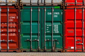 Stacked colorful containers in red, green, grey and bordeaux in the harbour of Duisburg Ruhrort...