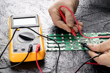 The master tests the LEDs on the microcircuit using a multi-meter. Checking LEDs. LEDs on a...