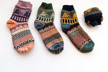 Various colourful Winter woollen socks isolated in a white background.