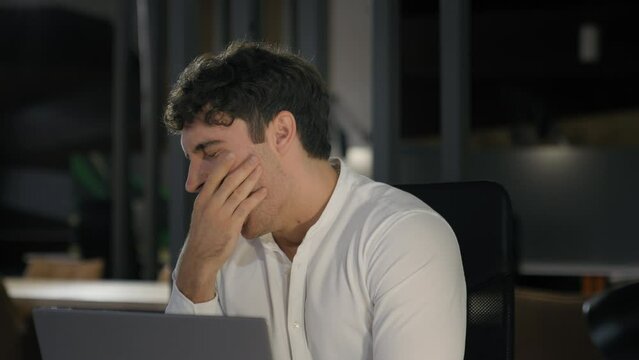 Tired exhausted Caucasian businessman fatigued overworked overload overtime working yawning at night evening office business man employer entrepreneur work with laptop yawn need sleep boring deadline