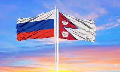 Russia and Nepal two flags on flagpoles and blue sky.