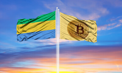 Bitcoin and Gabon two flags on flagpoles and blue sky.