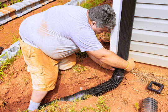 Installing connector downspout for flexible gutter extension drainage pipe with water draining down