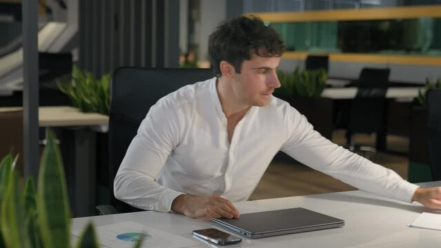 Caucasian tired exhausted fatigued overworked overload businessman accomplished online task computer work end off close laptop table lamp light business man take phone finish done job leaving office