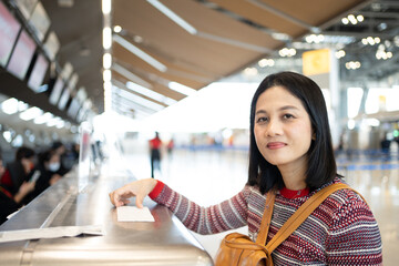 Asian woman short and black hair standing wait to check-in at counter in the airport.