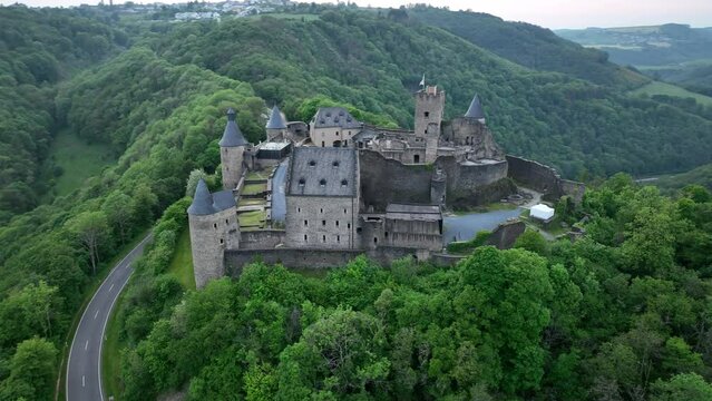 High drone footage of the medieval Bourscheid Castle at sunset in Bourscheid village, Luxembourg