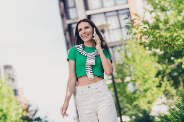 Photo of cute adorable girl dressed green top walking speaking apple samsung iphone modern gadget...