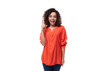 young dreamy caucasian business woman with wavy hair dressed in an orange blouse on a white background