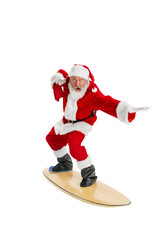 Senior man, Santa Claus with bag filled with presents surfing on board isolated on transparent background. Concept of winter holidays, Christmas and New Year, celebration, merry time