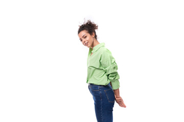 Fototapeta premium young well-groomed slender European brunette curly woman dressed in a green shirt on a white background