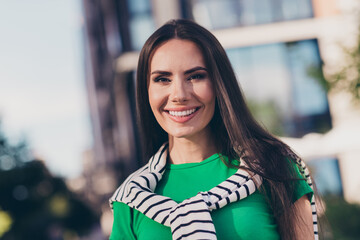 Photo of cheerful positive girl dressed green top smiling enjoying sunshine walking outdoors urban town park