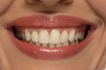 Fototapeta premium Close-up of a woman's mouth, capturing a confident smile and perfect natural teeth and lips