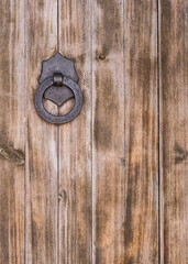 Part of a large wooden door with an iron handle and ring. Spain