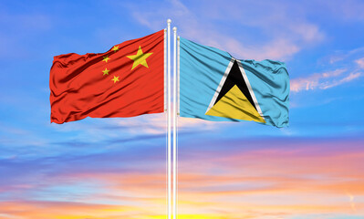 Flag of China and Saint Lucia waving in the wind against white cloudy blue sky together. Diplomacy concept, international relations