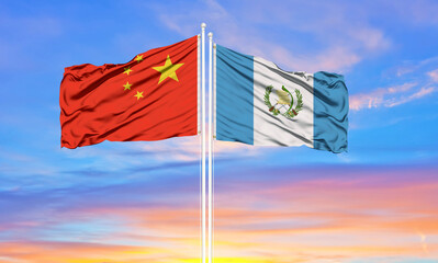China and Guatemala two flags on flagpoles and blue cloudy sky . Diplomacy concept, international relations