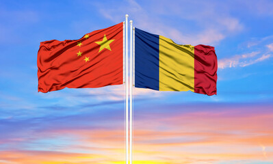 China and Romania two flags on flagpoles and blue cloudy sky . Diplomacy concept, international relations