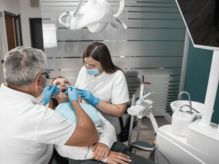 The photo shows how professional teeth cleaning ensures their impeccable cleanliness. A woman at an...