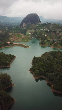 Aerial drone footage of El Penon de Guatape near Medellin in Antioquia, Colombia. Large and unique alone rock with stairs to the top, touristic place. Big stone in Colombia. High quality 4k footage.