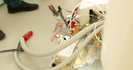The installation process of dental equipment, dental chair. Cables, wires, hoses and hands of a specialist in the installation of medical equipment.