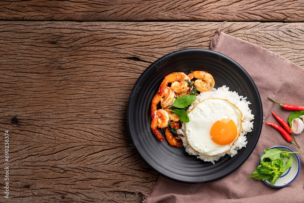 Sticker stir-fried shrimp with basil and eggs thai street food arranged on black plates spicy thai food plac