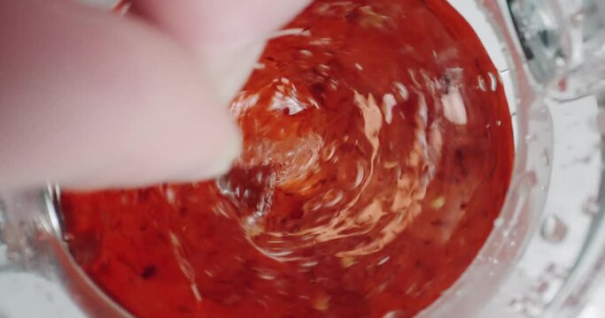 Spoon making a swirl spinning organic tea in glass teapot kattle, , cinematic isolated slow motion shot